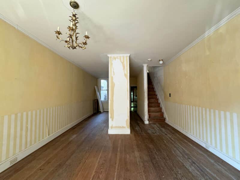 Open living and dining area with hardwood floors, tall ceilings, and decorative chandelier at 199 Prince George Street.