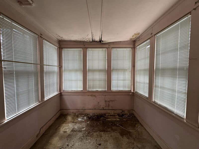Bonus room with three walls of windows and worn flooring at 909 Jackson Street NE in Brookland, Washington DC.