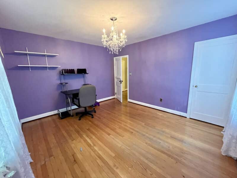 Bedroom with purple walls, hardwood floors, and a chandelier at 19 Dunmore Road.