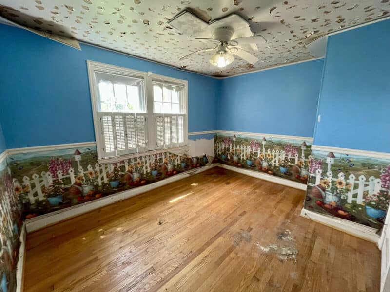 Colorful bedroom with hardwood flooring, large front window, and ceiling fan at 1729 Edgewood Road.