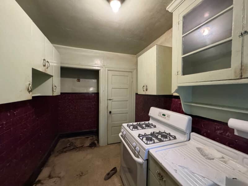 Galley-style kitchen with vintage cabinetry, gas stove, and partial tile backsplash at 909 Jackson Street NE, Washington DC.