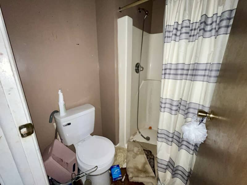 Full bathroom connected to main bedroom, featuring a walk-in shower, toilet, and laminate flooring at 12366 Bonfire Drive.
