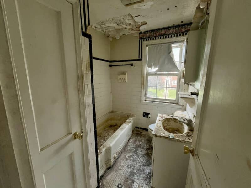 Bathroom with tub, sink, and visible ceiling damage at 1729 Edgewood Road.