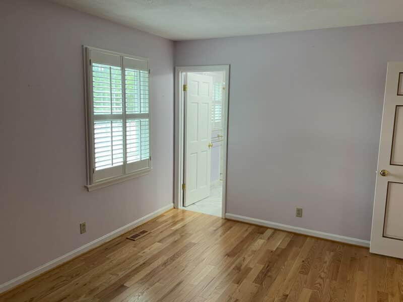 Bright bedroom with hardwood floors, plantation shutters, and en-suite bathroom in Dundalk, MD home.
