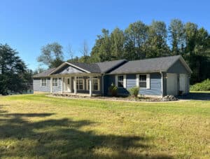 Front exterior view of a single-story ranch home with attached two-car garage and spacious front lawn.