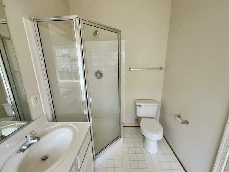 Full bathroom with glass shower enclosure, vanity, and toilet.
