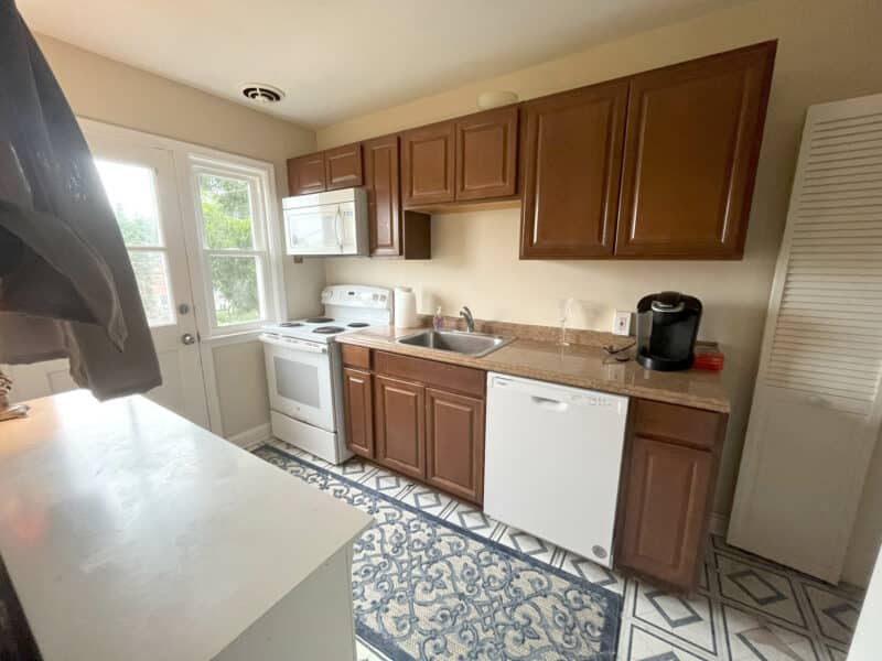 Kitchen with wood cabinets, white appliances, and back door access at 1000 Downton Road, Arbutus.