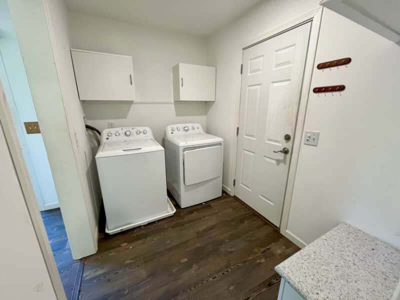 Laundry room with washer, dryer, cabinets, and utility access.