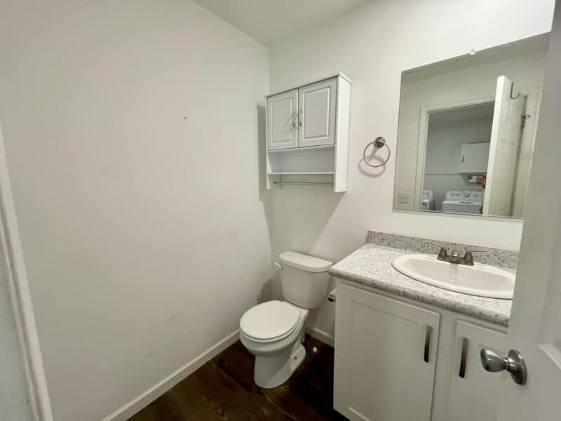 Half bathroom with vanity, toilet, and wall cabinet.