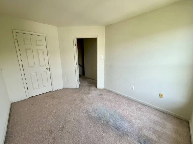 Carpeted bedroom with single closet and doorway to hall.