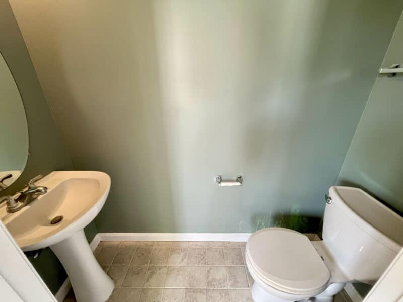 Half bathroom with pedestal sink and toilet.