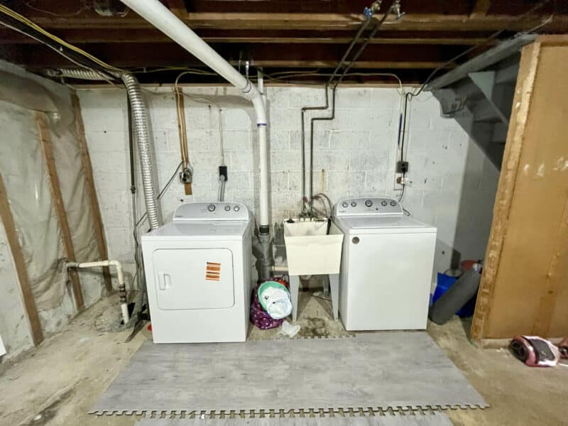 Brand new washer and dryer set with utility sink in basement laundry area at 1000 Downton Road, Arbutus.