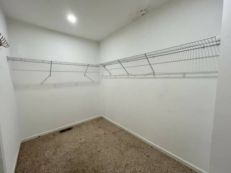 Walk-in closet with carpet and built-in wire shelving.