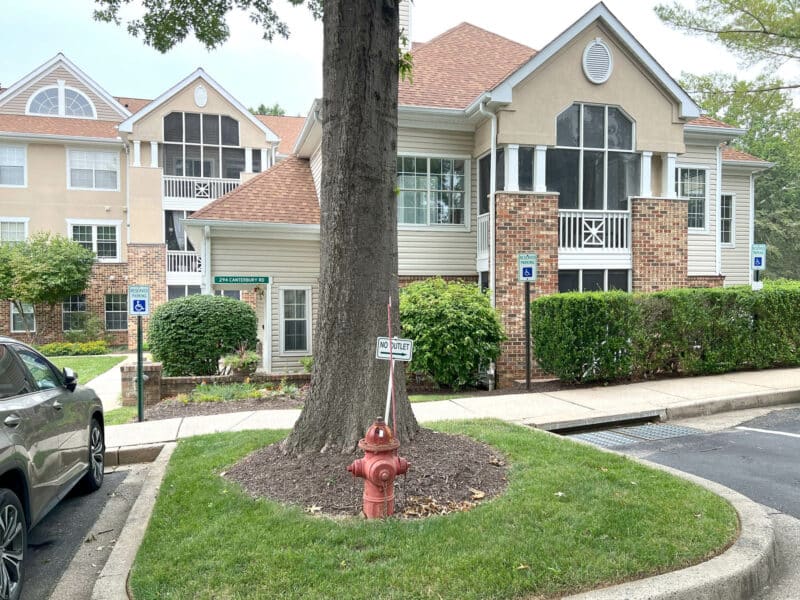 Exterior view of English Country Manor condominium building in Bel Air, Maryland, featuring landscaped grounds and accessible parking.