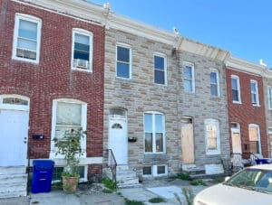 Two-story brick townhome at 2115 E. Federal Street in Broadway East, Baltimore, requiring full renovation.