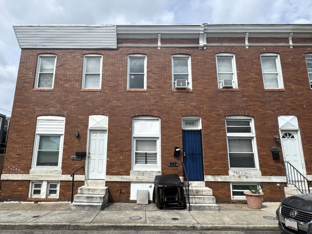 Front exterior view of 802 N. Glover Street, a two-story brick townhome in the Madison-Eastend neighborhood of Baltimore City.
