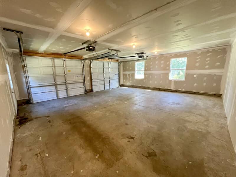 Two-car attached garage with concrete floor and automatic doors.