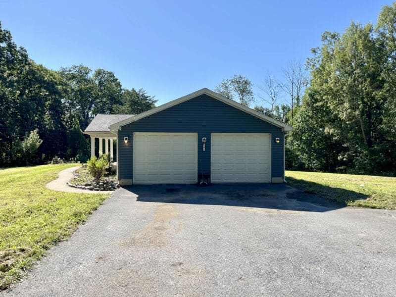 Front-facing view of attached two-car garage with driveway.