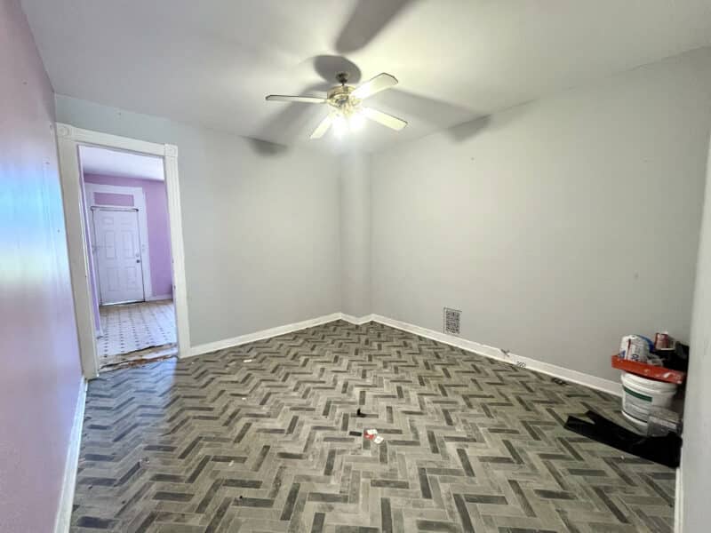 Dining room of 2115 E. Federal Street in Broadway East with gray herringbone vinyl flooring, white walls, and overhead ceiling fan.