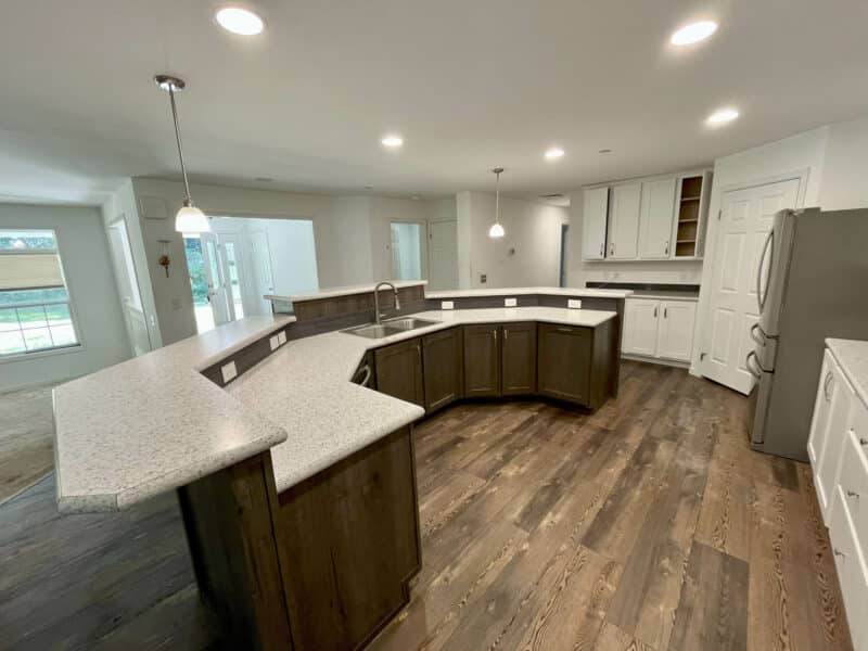 Alternate view of open kitchen with breakfast bar, pendant lights, and surrounding cabinetry.
