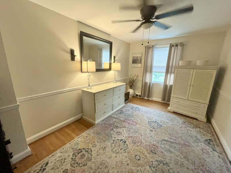 Dining room with wood floors, ceiling fan, and large window with curtains at 1000 Downton Road, Arbutus MD.