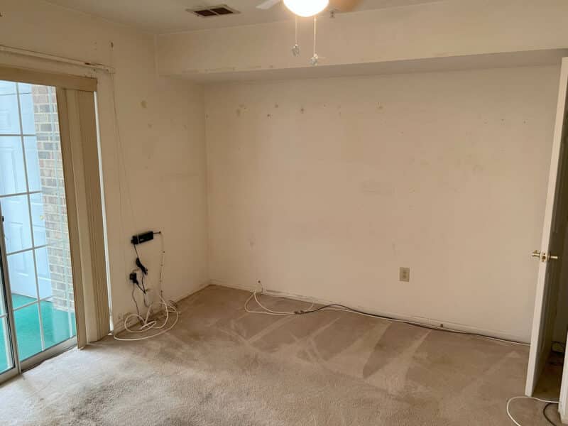 Second bedroom or den with sliding glass doors, carpeted floor, and ceiling fan in Bel Air condo.