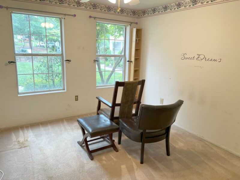 Main bedroom with two large windows, carpeted flooring, and floral wallpaper border in Bel Air condo.