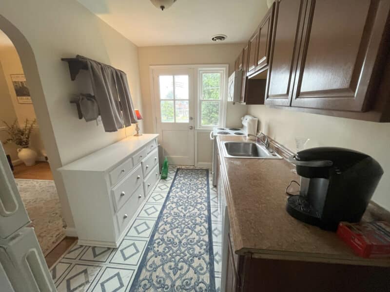 Galley-style kitchen with wood cabinets, laminate countertops, and patterned tile flooring at 1000 Downton Road in Arbutus, MD.