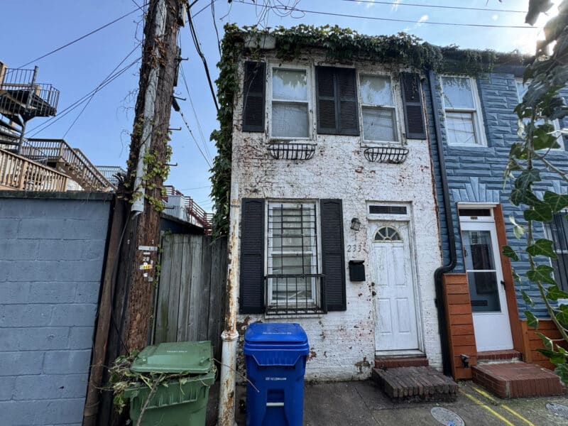 Front view of 2337 Duker Court, a two-story semi-detached brick townhome in Canton with white façade, black shutters, and side entrance.