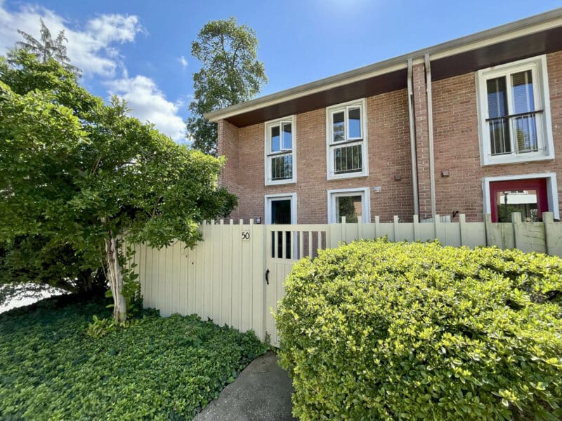 Front view of brick townhouse condo with fenced entry