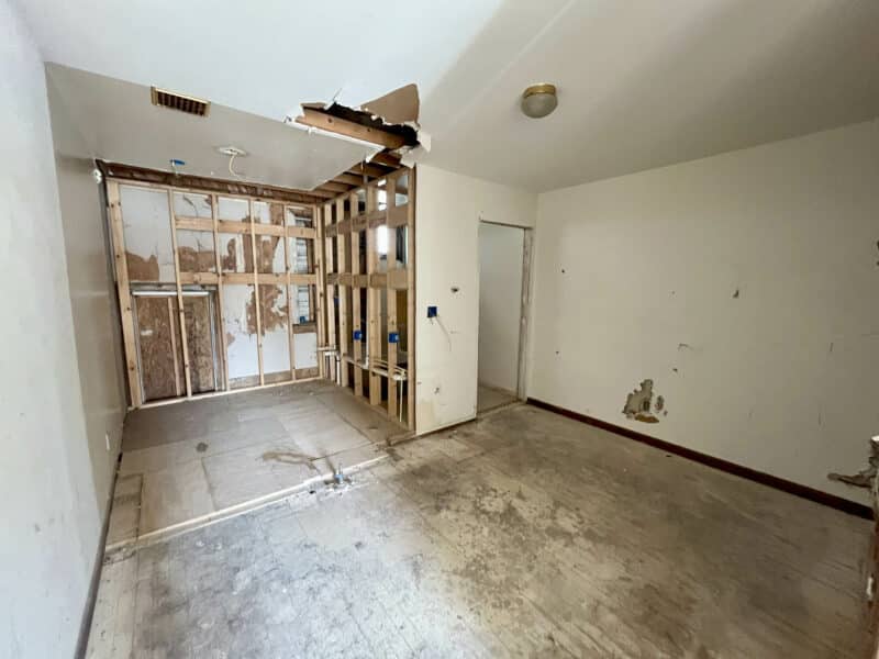 Upper level room with exposed framing and damaged ceiling.
