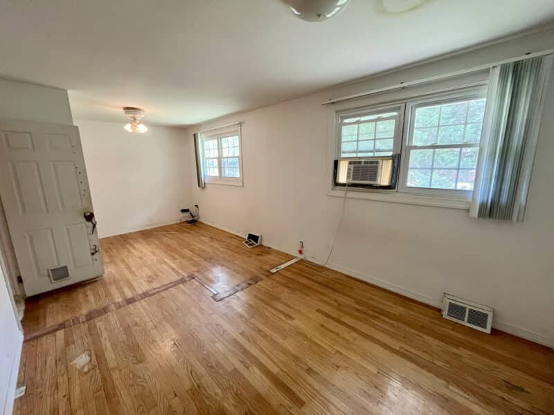 Bedroom with hardwood floors and large windows.
