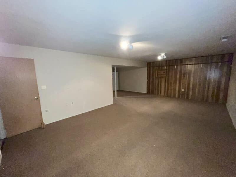 Spacious basement family room with carpet flooring, wood panel accent wall, and recessed lighting in Westminster, MD home.