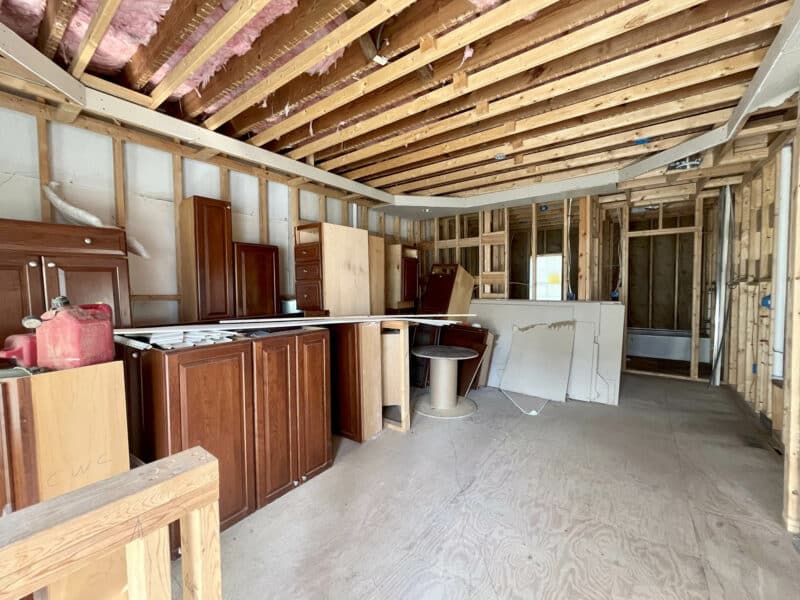 Framed interior area with unfinished cabinets and exposed insulation in ceiling.