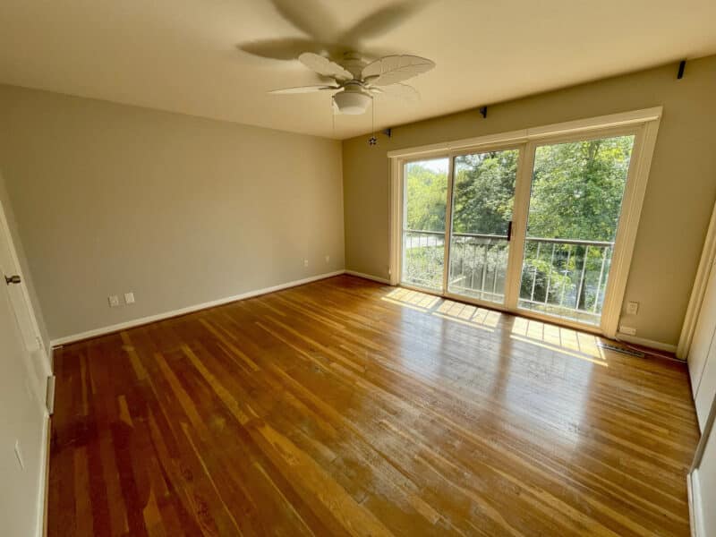 Bedroom with hardwood floors and balcony access