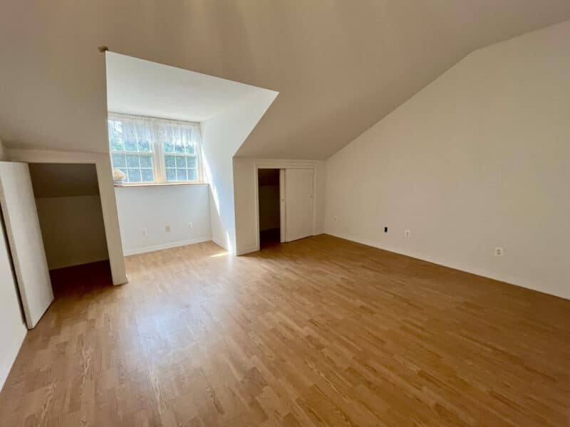 Second-floor bedroom with vaulted ceiling and dormer window.