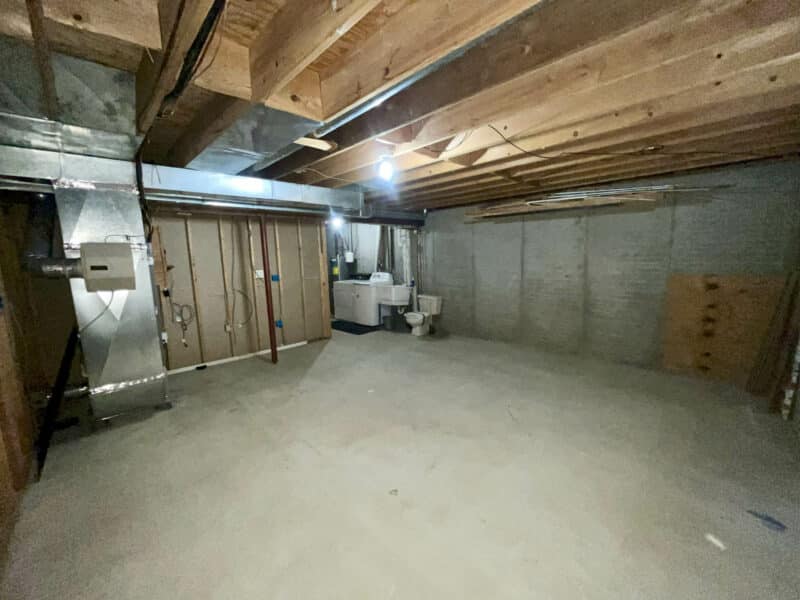Laundry and utility room with exposed ceiling beams, HVAC system, sink, and washer/dryer hookups in basement of Westminster rancher.