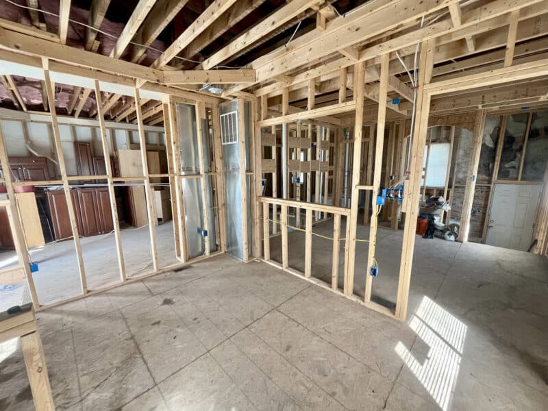 Corner room under construction with wood framing and electrical rough-ins.