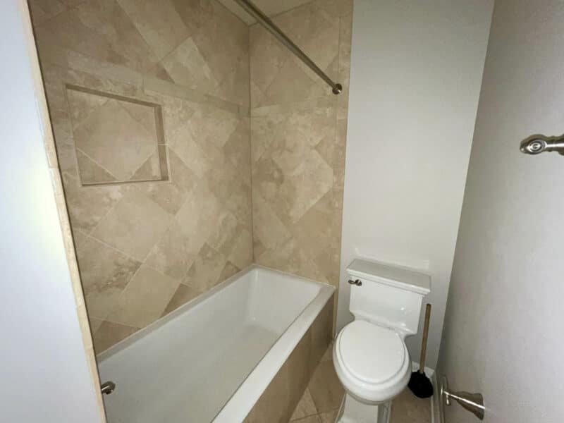 Bathroom with tub and tiled walls