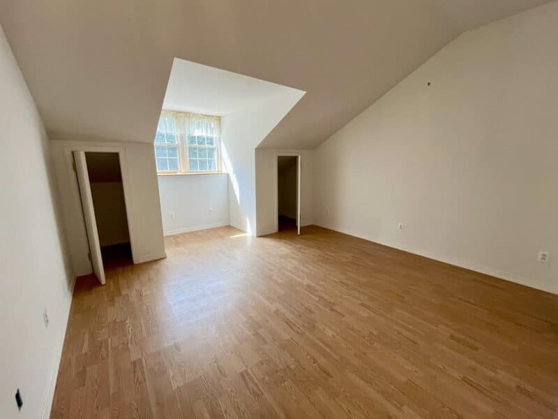 Second-floor bedroom with vaulted ceiling and dormer window.