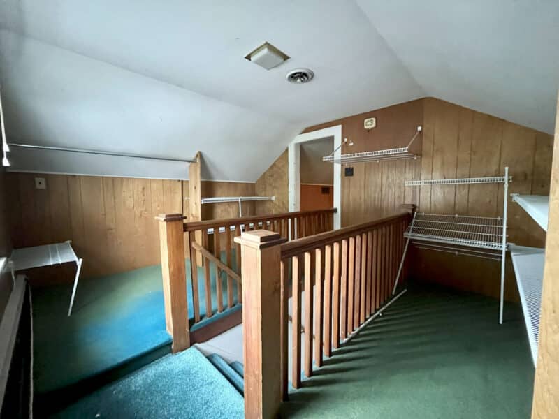 Upper level landing with wood paneling and shelves at 7245 Meadow Lane.