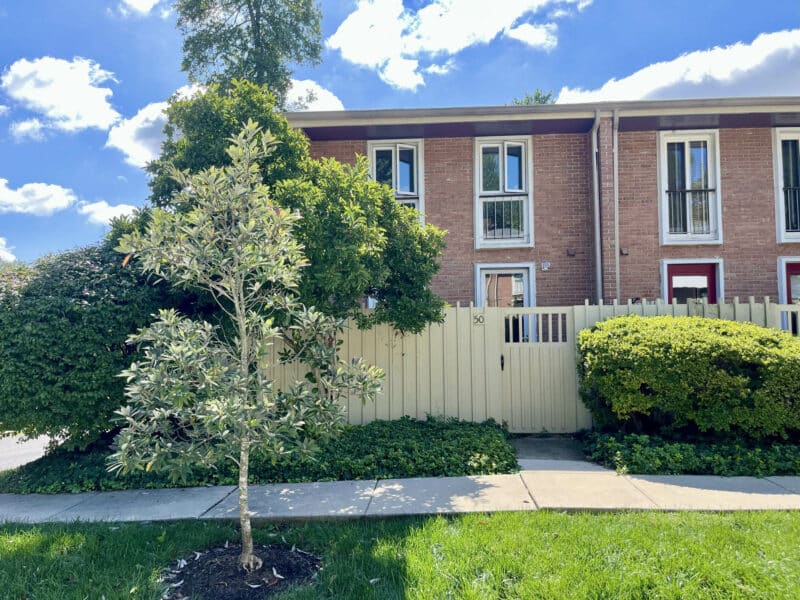 Front view of townhouse condo unit with white fence