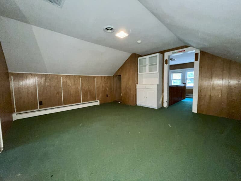 Upper-level bedroom with green carpet in Dundalk Farms rancher.