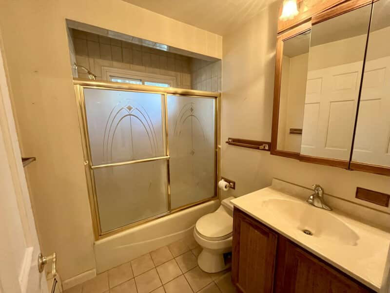 Hall bathroom with vanity and gold-trimmed tub/shower at 7245 Meadow Lane.