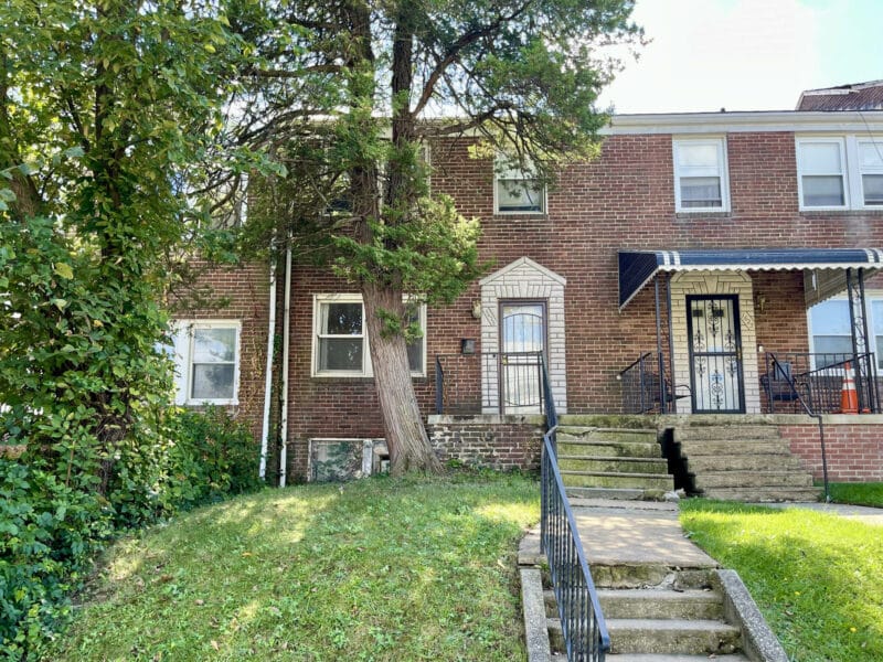 Front exterior of brick two-story Hillen townhome at 1625 Argonne Drive with steps, railings, and small front yard.