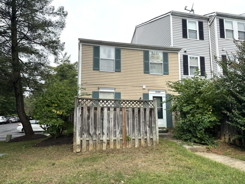 Front exterior of two-story end-of-group townhome with fenced courtyard in Silver Spring.