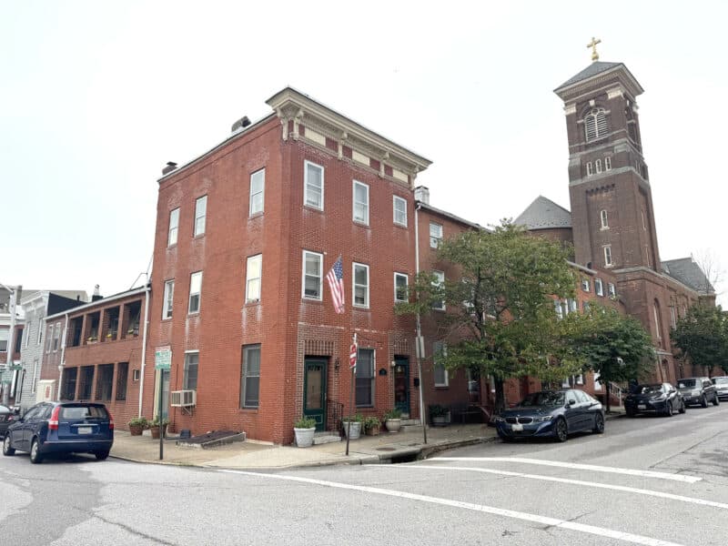 Wide-angle exterior of 1021 Stiles Street with adjacent church tower visible