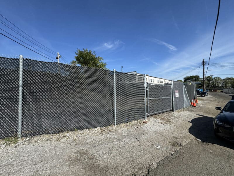 Street view of fenced 0.052-acre industrial storage lot on Langley Street in Southwest Baltimore.