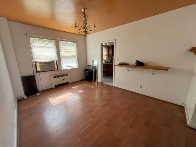 Dining room with laminate flooring, chandelier, and windows at rear of Hillen townhome.