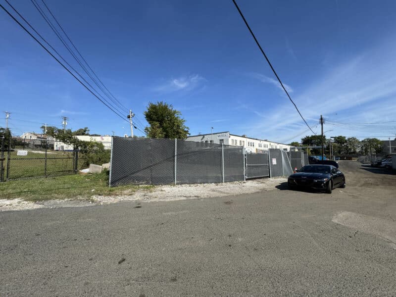 Street view of fenced 0.052-acre industrial storage lot on Langley Street in Southwest Baltimore.